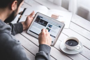 Image of man using an ereader to access content.