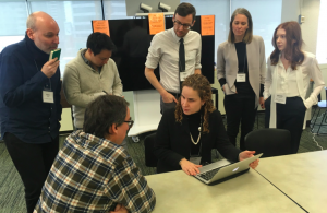 Group of delegates talking to Daniella at the Accessibility Summit in January 2019