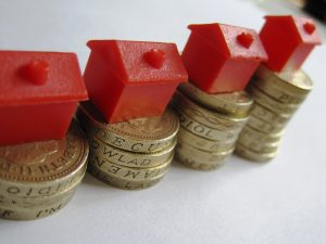 Monopoly hotel atop of a pile of coins symbolizing inheritance tax