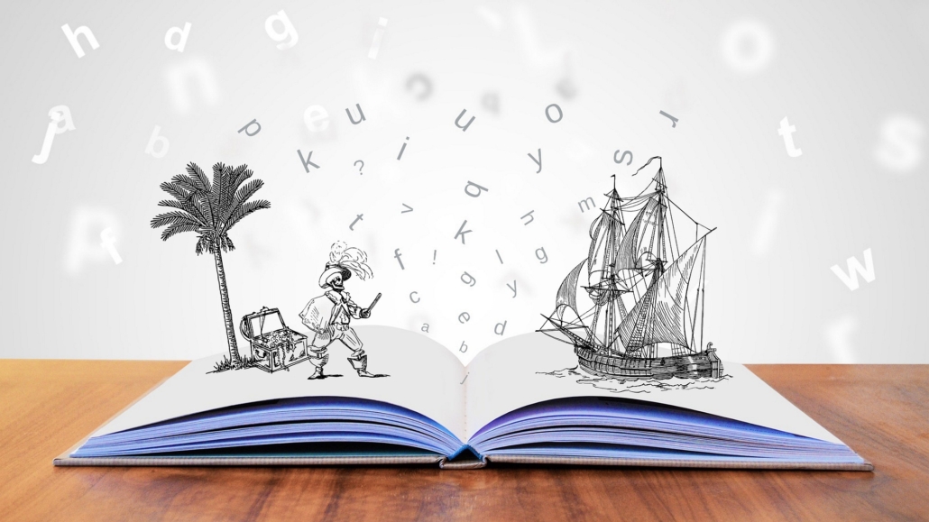A blank open book with pop ups standing up on each side of the spread and the letters from the page circling above. The pops are pirate themed - a pirate on a desert island finding treasure on the left and the pirate ship on the right.