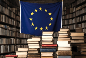 image of the EU flag amongst full bookcases and a desk piled high with books