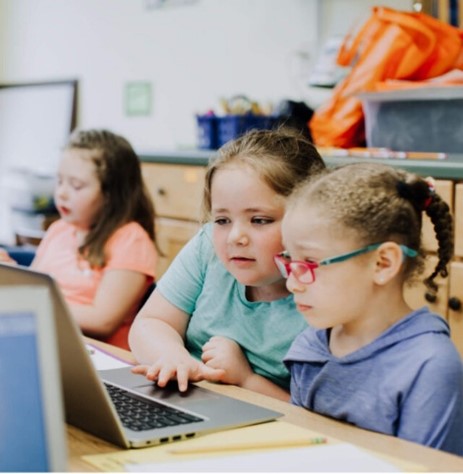 A group of children looking at a laptop.